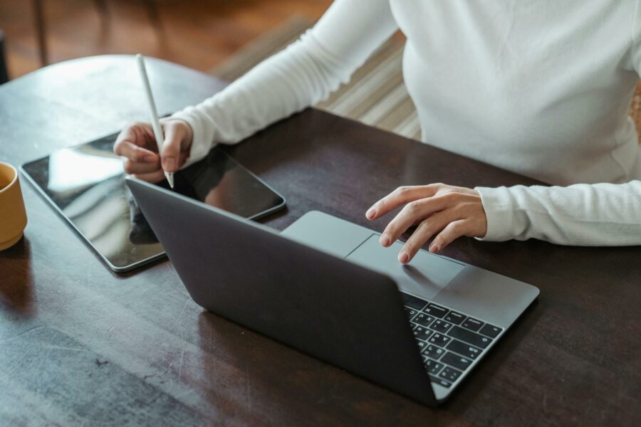 woman sitting at laptop computer with tablet
